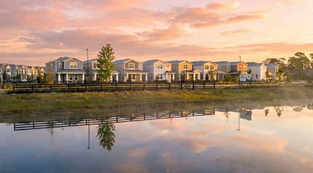 Houses along a tranquil pond at Center Lake on the Park in St. Cloud, FL, showcasing the community's connection to nature and vibrant living environment.